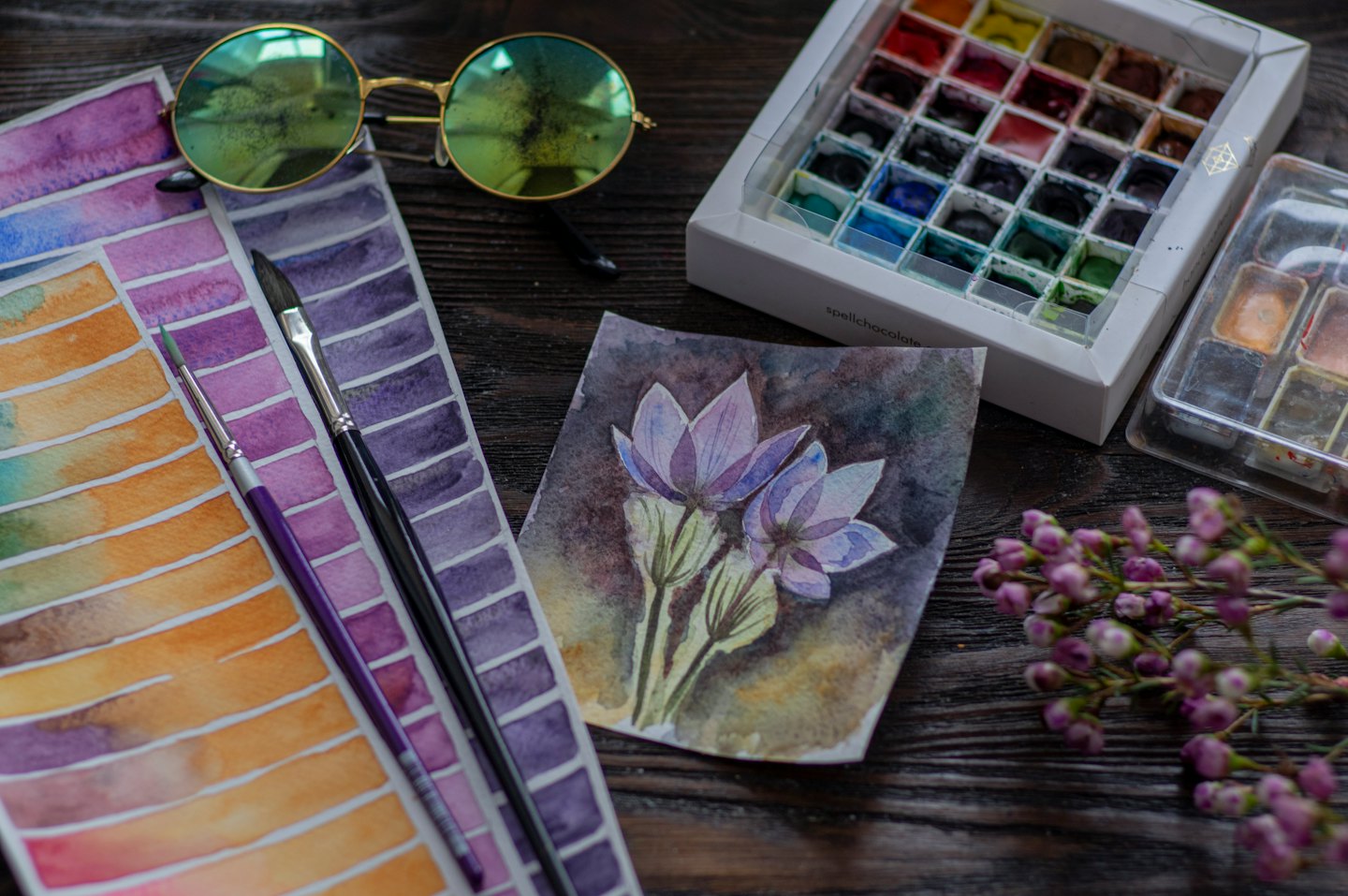 Aquarell-Malutensilien und ein kleines Gemälde auf Holz.