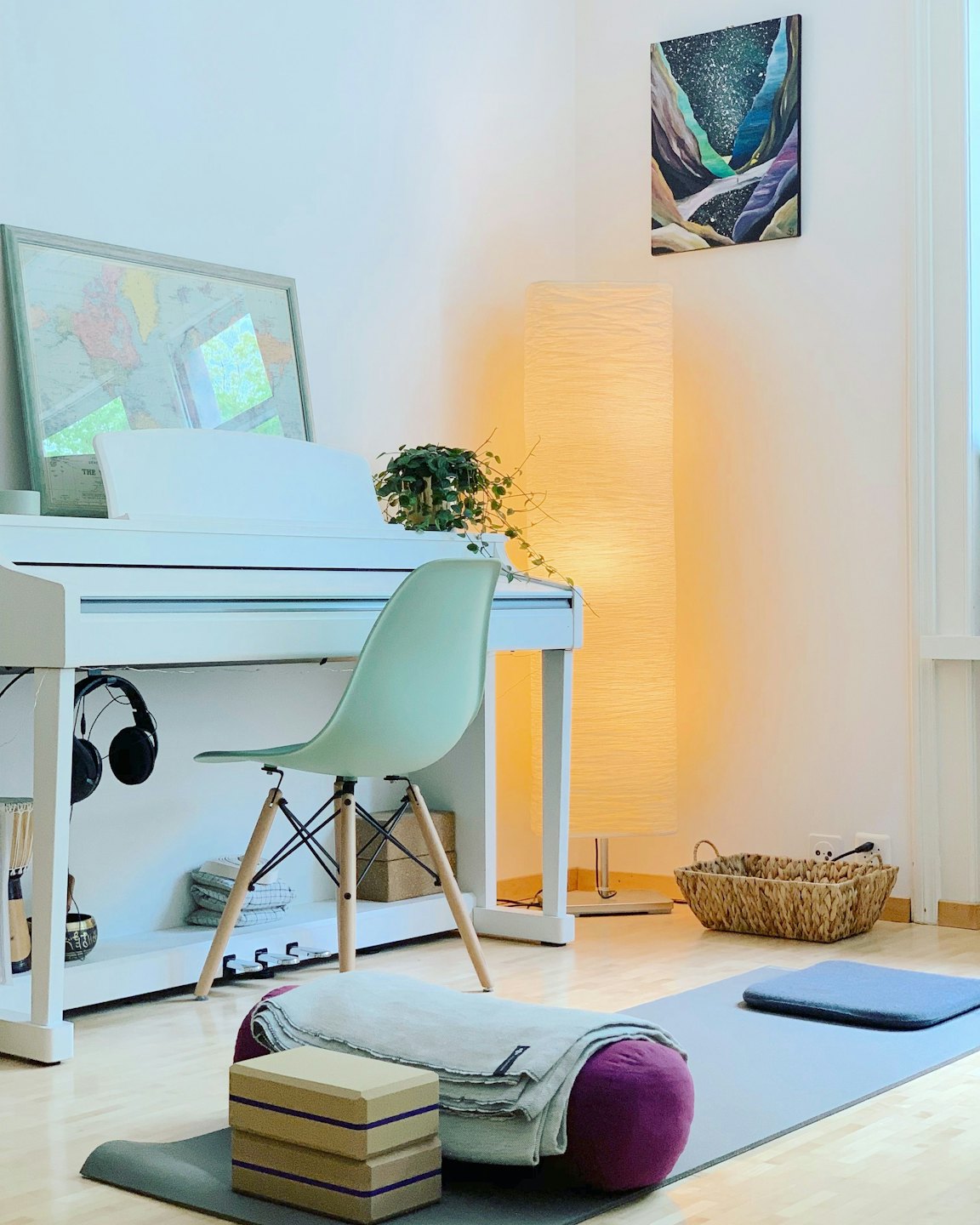 Wohnlicher Raum mit Yogamatte, Stuhl und Klavier.