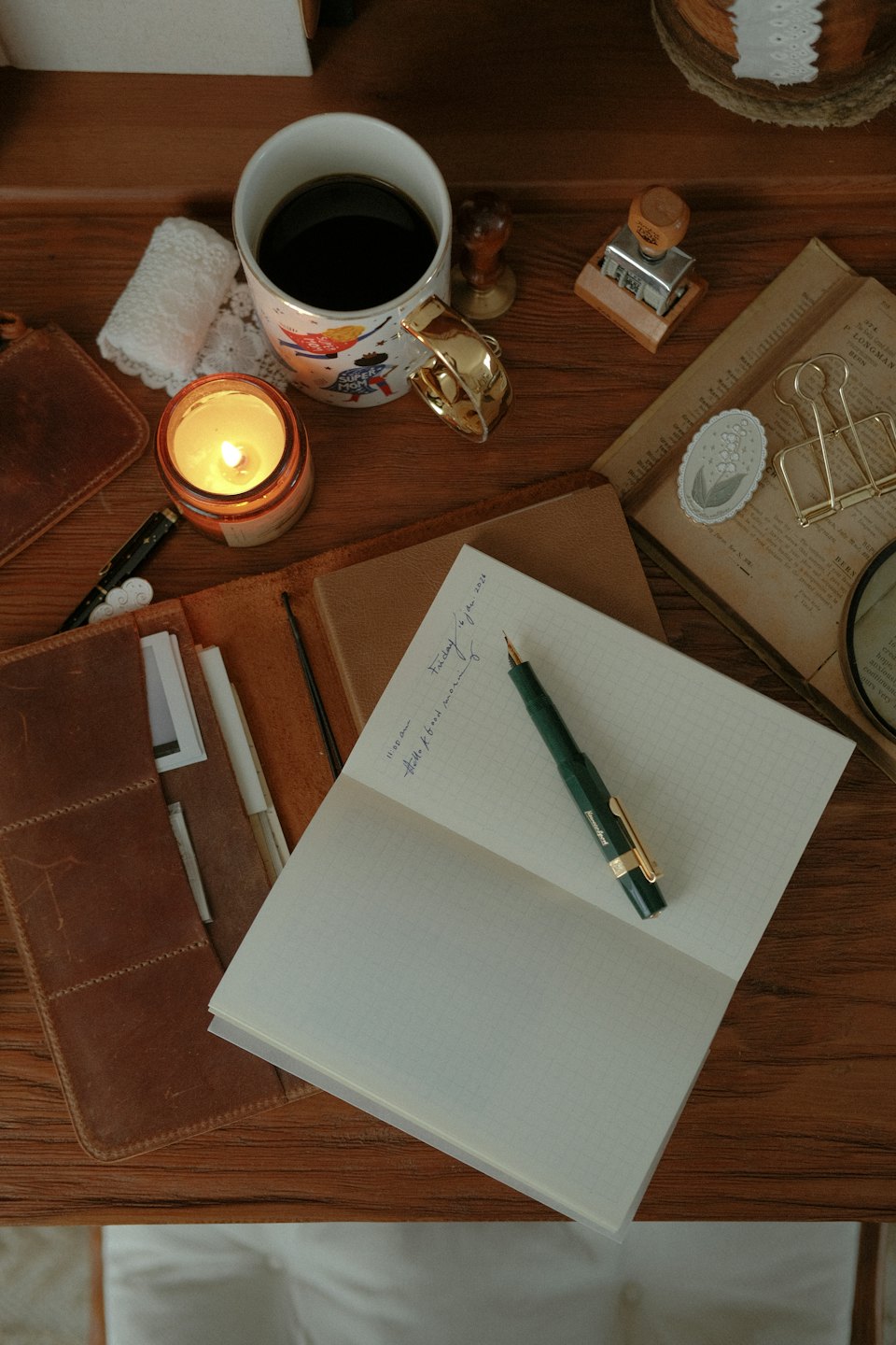 Schreibtisch-Aufnahme mit Notizbuch, Füllfederhalter und Kaffee.