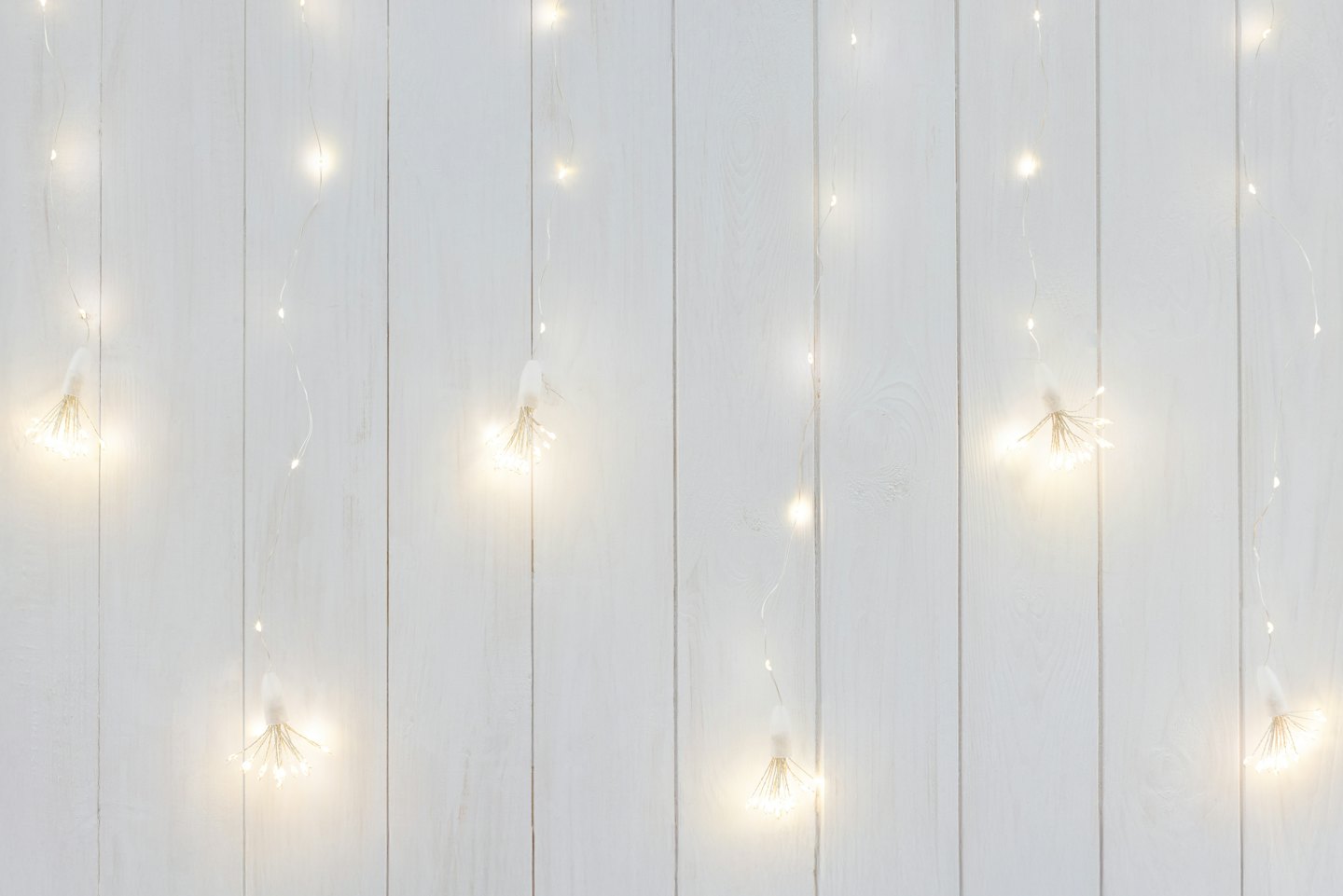 Lichterkette leuchtet vor einer holzvertäfelten Wand.